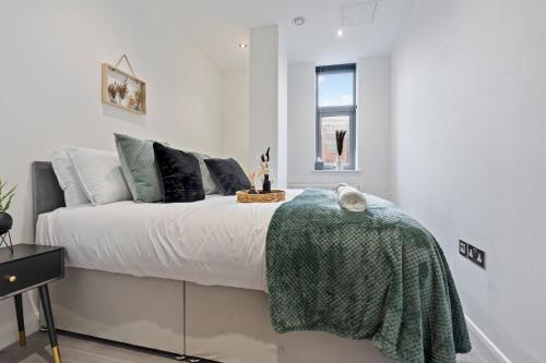 a bedroom with a bed with a green blanket on it at The Emerald Residence - Leicester - City Centre, Sofa Bed, Parking, Free WiFi, Netflix in Leicester