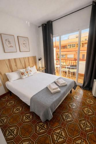 a bedroom with a large bed and a large window at CASA MILA SV19 guesthouse in Alicante