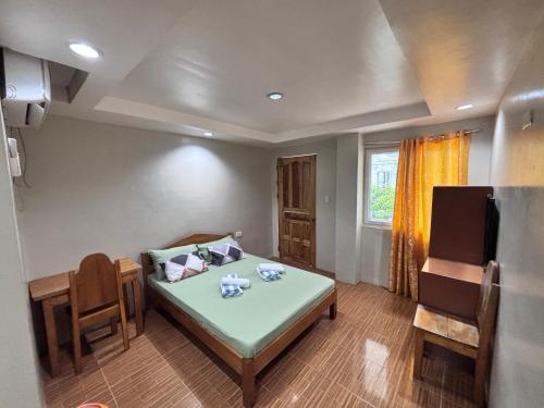 a small room with a bed and a table at Eme's Apartelle in General Luna