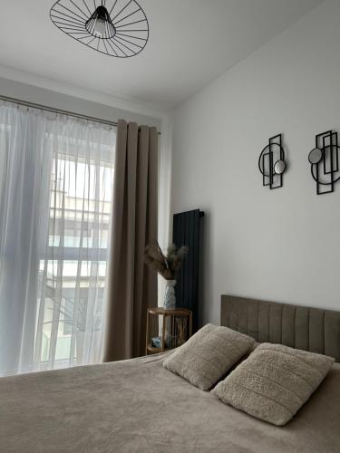 a bedroom with a large bed and a window at Apartament Parkowa-prywatny parking in Olecko