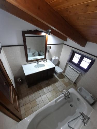 a bathroom with a tub and a sink and a mirror at Casa Vacanza Dal Contadino in Corteno Golgi