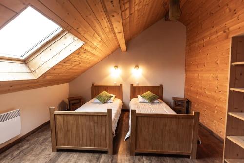 two beds in a room with two windows at Gite du Brin d'Herbe in Pontarlier