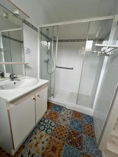 a bathroom with a sink and a shower at Hôtel Le Square in Capvern
