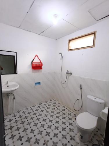 a bathroom with a toilet and a sink at Leokap Homestay in Tuktuk Siadong