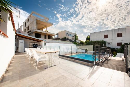 a patio with a table and chairs and a swimming pool at Villa A'Mare in Seget Vranjica
