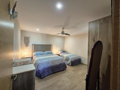 a bedroom with two beds and a table with lights at Casa de los Suenos Granada in El Turro