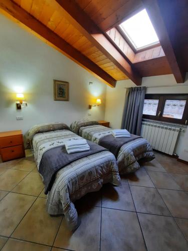 three beds in a room with a skylight at Casa Vacanza Dal Contadino in Corteno Golgi