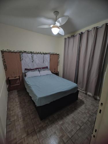 a bedroom with a bed and a ceiling fan at Aconchego famíliar in Mongaguá