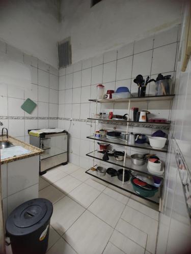a kitchen with a shelf with pots and pans at Aconchego famíliar in Mongaguá