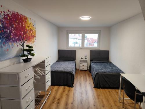 a bedroom with two beds and a desk and a table at FeWo Relaxfit in Bad Buchau