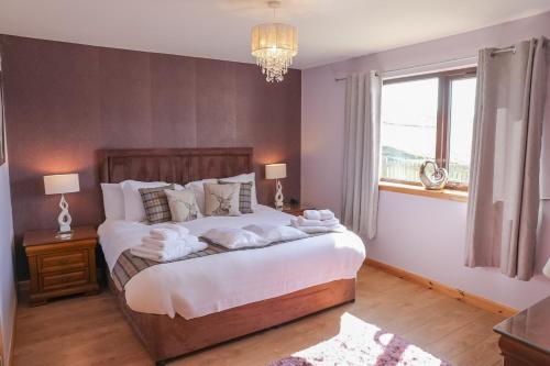 a bedroom with a large bed with towels on it at Otter Cottage in Leverburgh