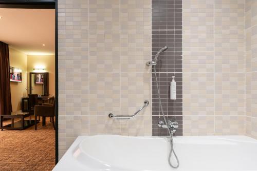 a bathroom with a bath tub with a shower at Hotel 33 Kampala in Kampala