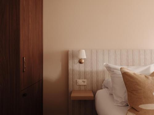 a bedroom with a bed with white pillows and a lamp at Adam's Museum House in Amsterdam