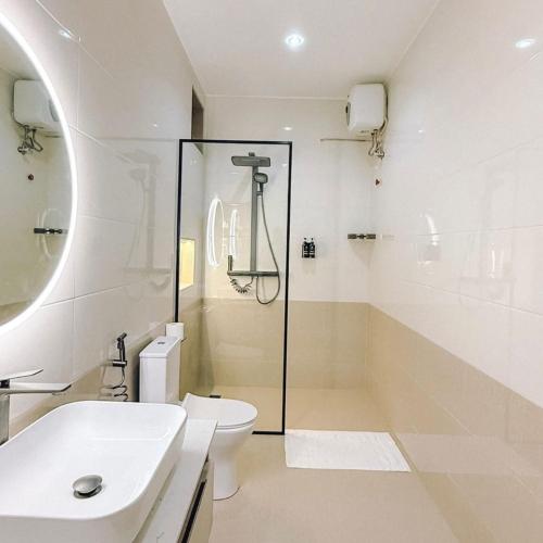 a bathroom with a shower and a toilet and a sink at The Lemiray Hotel in Dodoma