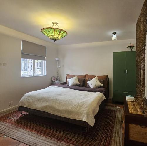 a bedroom with a large bed and a chandelier at Farm Cottage in Hong Kong