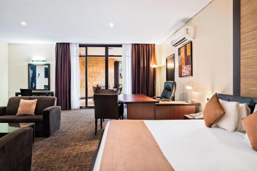a hotel room with a bed and a desk at Hotel 33 Kampala in Kampala