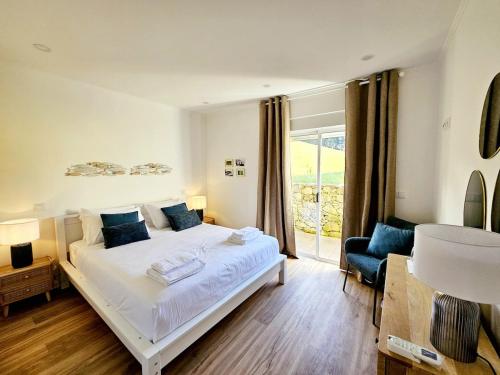 a bedroom with a white bed and a window at The Yellow Cottage in Lomba de São Pedro