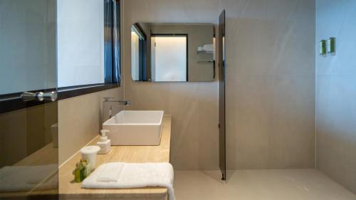 a bathroom with a sink and a mirror at 온더웨이브호텔 in Taesong