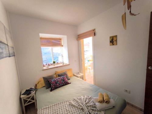 a bedroom with a bed with shoes on it at RenTenerife EspebelBeach in El Médano