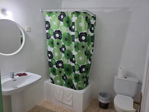 a bathroom with a toilet and a shower curtain at Pensión Restaurante Páramo in La Herradura