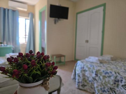 a room with a vase with purple flowers in it at Pensión Restaurante Páramo in La Herradura