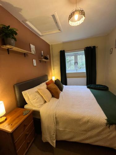 a bedroom with a bed and a window at Gamekeepers Cottage, hot tub & open fire. in Gaywood