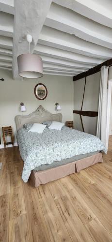 a bedroom with a large bed and a wooden floor at LA GAUDINIERE in Lyons-la-Forêt