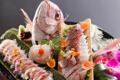 a plate of food with a fish and sushi at Hotel Tokinoza in Kihokucho