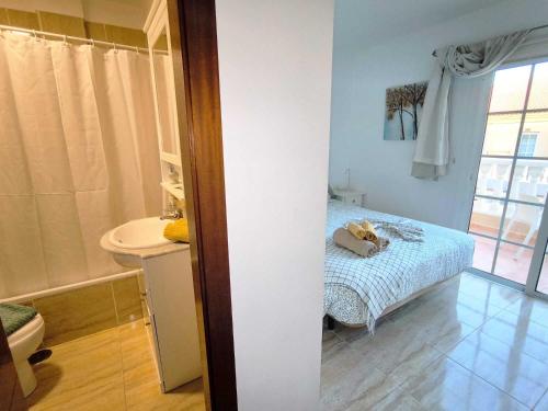 a room with a bed and a bathroom with a toilet at RenTenerife EspebelBeach in El Médano