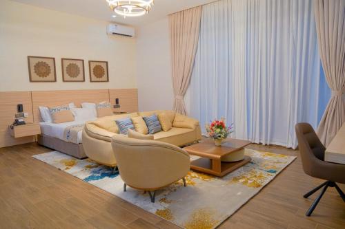 a bedroom with a bed and a couch and a table at The Lemiray Hotel in Dodoma