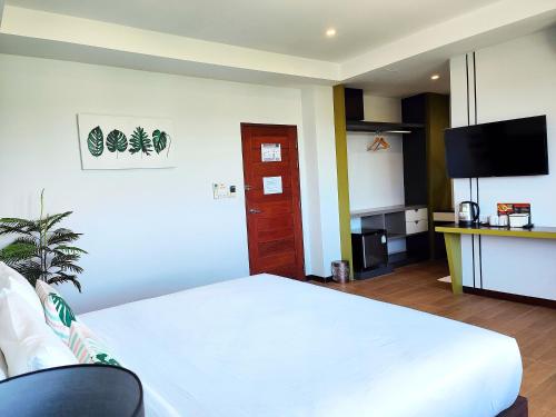a bedroom with a white bed and a television at โคโค่ โฮเทล KOCO Hotel in Nakhon Ratchasima
