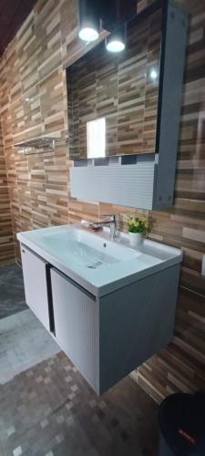 a bathroom with a white sink and a mirror at Otila Bali Villa in Uluwatu