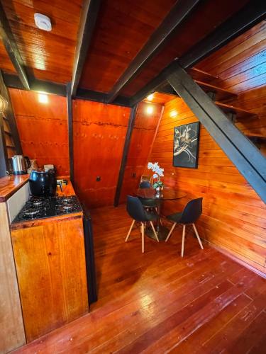 a kitchen with a stove and a table with chairs at Recanto Porto Chalé e SPA in Penha