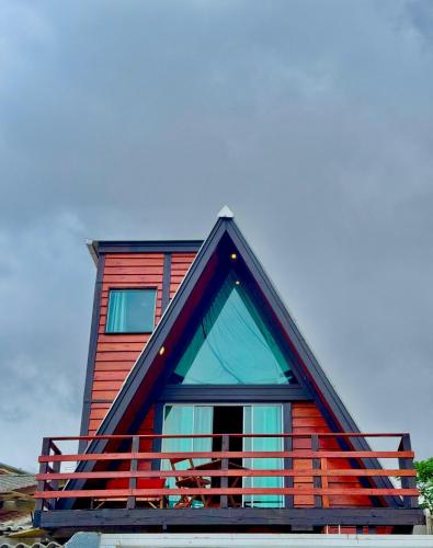 a house with a thatched roof with a window at Recanto Porto Chalé e SPA in Penha