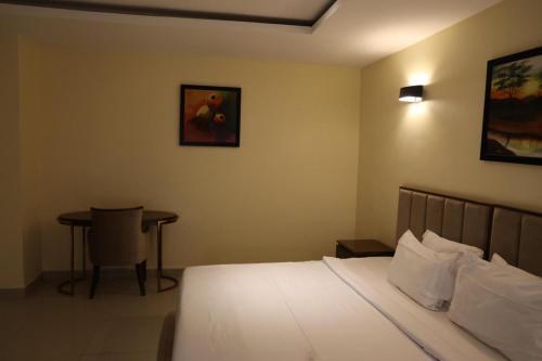 a bedroom with a bed and a table in it at Golden Alpine Hotel in Yola