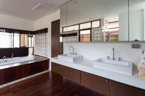 a bathroom with two sinks and two mirrors at Amatapura Beachfront Villa 10 , SHA Certified in Ao Nam Mao