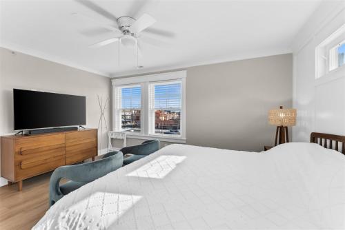 a white bedroom with a bed and a flat screen tv at 921 Asbury Ave, Unit C in Ocean City