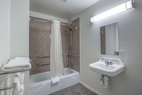 a white bathroom with a sink and a shower at Motel 6-Pasadena, TX in Pasadena