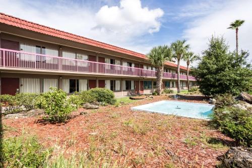 an exterior view of a building with a swimming pool at Motel 6-Spring Hill, FL - Weeki Wachee in Weeki Wachee