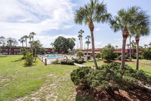 a yard with a swimming pool and palm trees at Motel 6-Spring Hill, FL - Weeki Wachee in Weeki Wachee