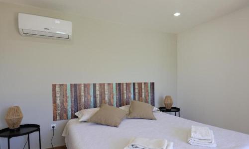 a bedroom with a white bed with two towels on it at Casa do Alpendre in Arco de Baúlhe