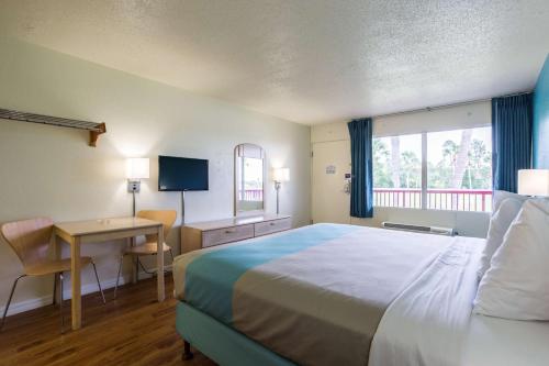 a hotel room with a bed and a desk with a computer at Motel 6-Spring Hill, FL - Weeki Wachee in Weeki Wachee