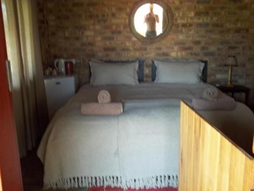 a bedroom with a large bed with towels on it at Tranquillity Day Spa & Lodge in Baviaanspoort
