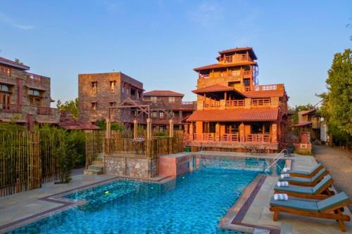 a house with a swimming pool next to a building at Seraibagh Ranthmabore in Khilchipur