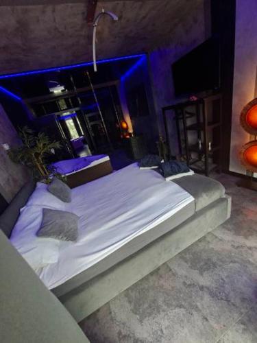 a large bed in a room with blue lighting at SECRET LOVE studio in Ełk