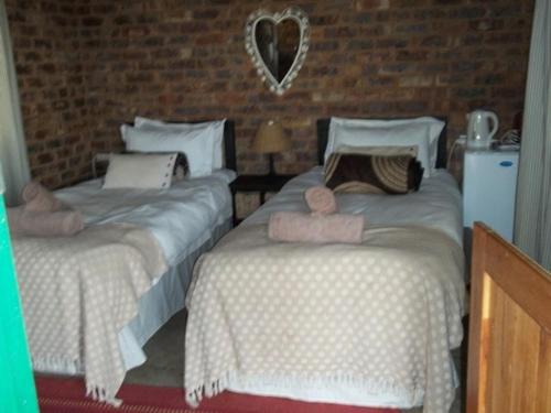 a bedroom with two beds with towels on them at Tranquillity Day Spa & Lodge in Baviaanspoort