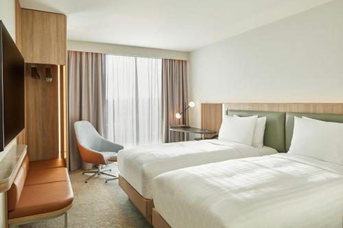 a hotel room with two beds and a desk at Courtyard by Marriott Sheffield in Sheffield