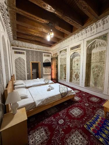 a bedroom with a large bed and a red carpet at Boutique ALISHER in Bukhara