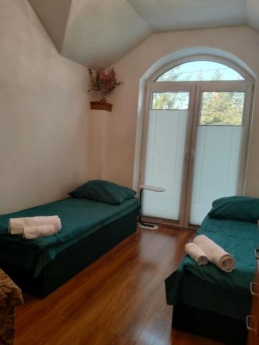 a room with two beds and a window at Villa Varzob in Warsaw