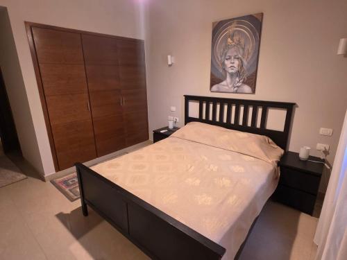 a bedroom with a bed and a painting on the wall at Blue haven el gouna in Hurghada